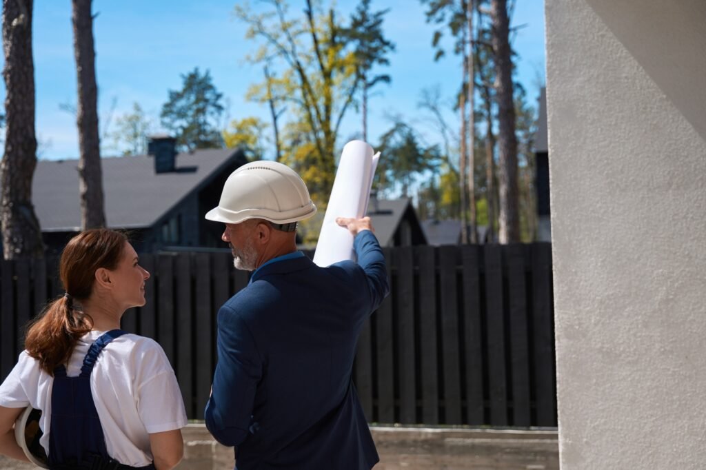 Man cadastral worker holding surveyor map and pointing at construction site